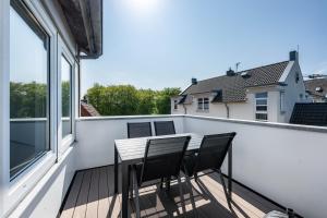 a balcony with a table and two chairs on it at Ferienwohnung mit Dachterrasse in Heide