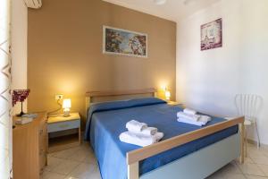 a bedroom with a blue bed with towels on it at Villa Forino Ragusa in Santa Maria del Focallo