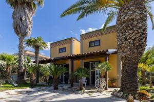 a building with palm trees in front of it at Villa Forino Ragusa in Santa Maria del Focallo