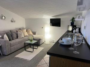 a living room with a couch and a table with wine glasses at Wolfbachgut - Ferienwohnung 5 in Taxenbach