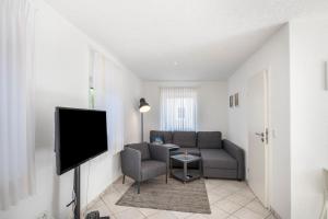 a living room with a couch and a tv at Strandnaher Bungalow in Dierhagen