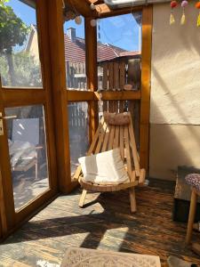 a wooden rocking chair on a porch with a window at Haus herhönspatziert in Willmars