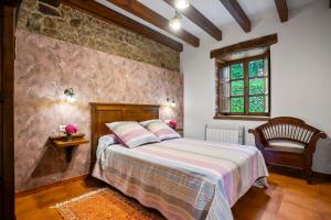 a bedroom with a bed and a stone wall at Casa Jesusa in Gijón