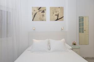 a white bedroom with a white bed with white pillows at Lovely seaview apartment in Benalmadena Costa +23 photos