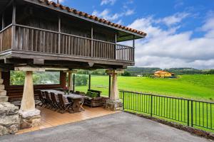 a patio with a deck with a table and chairs at Casa Jesusa in Gijón