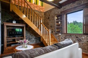 a living room with a couch and a staircase at Casa Jesusa in Gijón