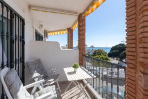 a balcony with chairs and a table on a balcony at Lovely seaview apartment in Benalmadena Costa