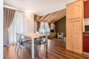 a kitchen and dining room with a table and chairs at Appartamento Ciasa in Pozza di Fassa