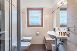 a bathroom with a toilet and a sink at Appartamento Ciasa in Pozza di Fassa +19 photos