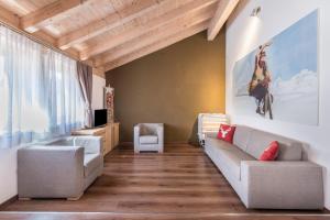 a living room with a couch and a chair at Appartamento Ciasa in Pozza di Fassa