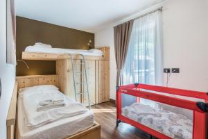 a room with two bunk beds and a window at Appartamento Ciasa in Pozza di Fassa