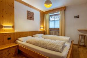 a bedroom with a bed in a room with a window at Apartment Pordoi in Campitello di Fassa