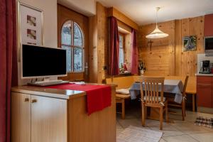a kitchen and dining room with a television on a counter at Apartment Pordoi in Campitello di Fassa +16 photos