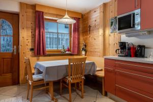 a kitchen with a table and chairs in a room at Apartment Pordoi in Campitello di Fassa