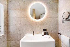 a bathroom with a white sink and a mirror at Appartement in Wangen im Allgäu +10 photos