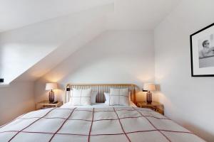 a bedroom with a large white bed with two lamps at Appartement in Wangen im Allgäu