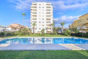 a swimming pool in front of a tall building at Penthouse studio with sea views in La Cala de Mijas +11 photos