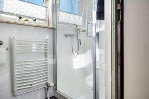 a shower with a glass door in a bathroom at Ferienhaus Ihme in Sande +21 photos