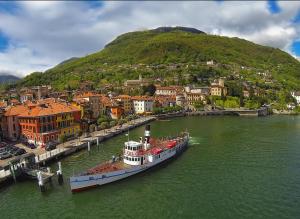 a boat is docked in a river next to a city at Elegant Central Large House F1F2 in Gravedona