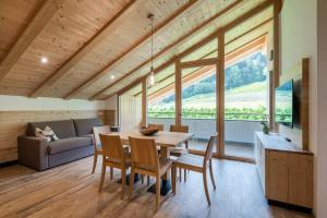 a dining room with a table and chairs and a couch at Natur Suite Edelweisshof App Georg in Chiusa