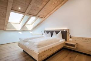 a bedroom with a large bed in a attic at Natur Suite Edelweisshof App Georg in Chiusa