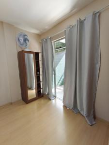 an empty room with curtains in front of a door at 800m da UFV, 500m da rodoviária, Wi-Fi, TV smart. in Viçosa
