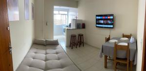 a living room with a table and a kitchen at 800m da UFV, 500m da rodoviária, Wi-Fi, TV smart. in Viçosa
