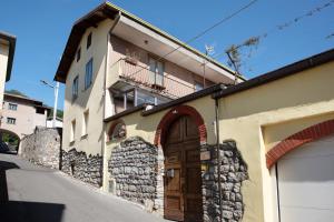 a building with a wooden door on a street at Ca Del Tita in Capo di Ponte