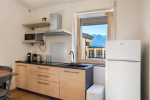 a kitchen with a white refrigerator and a window at Ca Del Tita in Capo di Ponte