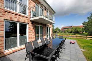 a patio with a table and chairs and a building at Ferienhaus Ebbe in Schülp