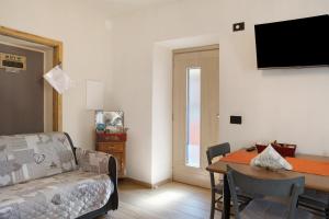 a living room with a couch and a dining room table at Ca Del Tita in Capo di Ponte
