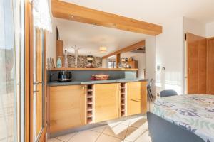 a kitchen with wooden cabinets and a bed in a room at Maison Vacances Vue Montagnes in Arras-en-Lavedan