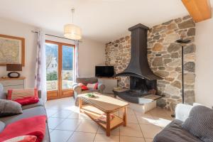 a living room with a large stone fireplace at Maison Vacances Vue Montagnes in Arras-en-Lavedan