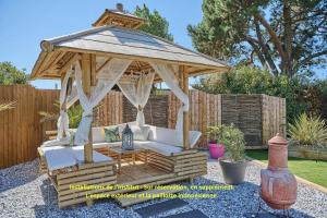 a wooden gazebo in a garden at Gite Escale Bien Etre à Biscarrosse in Biscarrosse