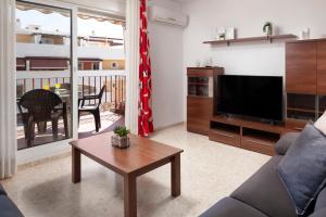 a living room with a couch and a tv and a table at Apartamento Sugar Factory in Torre del Mar