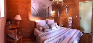 a bedroom with a bed and a table with a lamp at Gite Escale Bien Etre à Biscarrosse in Biscarrosse