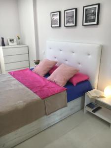 ロス・クリスティアーノスにあるApartment Los Cristianosのベッドルーム1室(ピンクの枕が付いた大型ベッド1台付)