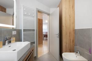 a bathroom with a white sink and a mirror at Night and day 4 in Predazzo