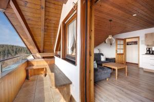 a living room and balcony of a log cabin at Haus Kandelblick in Furtwangen