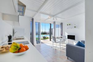a kitchen and living room with a bowl of fruit on a counter at Casa Amanecer 2 in Mácher