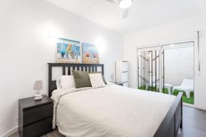 a white bedroom with a bed and a window at Chalet Saler in Valencia