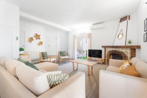 a living room with white furniture and a fireplace at Chalet Saler in Valencia