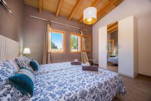 a bedroom with a large bed with blue and white sheets at Finca Ca S'Hereu Mas in Campos +22 photos