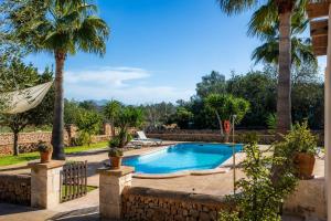 a swimming pool in a yard with palm trees at Finca Ca S'Hereu Mas in Campos