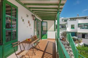 a balcony with a table and chairs on a building at El Gin in Playa Blanca