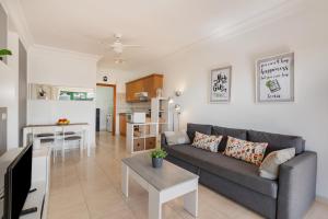 a living room with a gray couch and a kitchen at El Gin in Playa Blanca