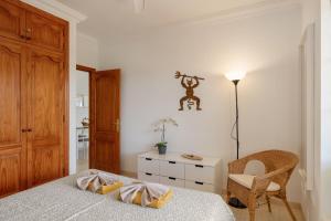 a bedroom with a bed and a chair and a table at El Gin in Playa Blanca