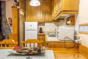 a kitchen with wooden cabinets and a white refrigerator at Apartamento La Mainera in Espot +11 photos