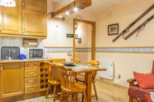 a kitchen with a table and chairs in a room at Apartamento La Mainera in Espot