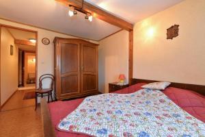 a bedroom with a bed and a wooden cabinet at Les Hirondelles in Orbey
